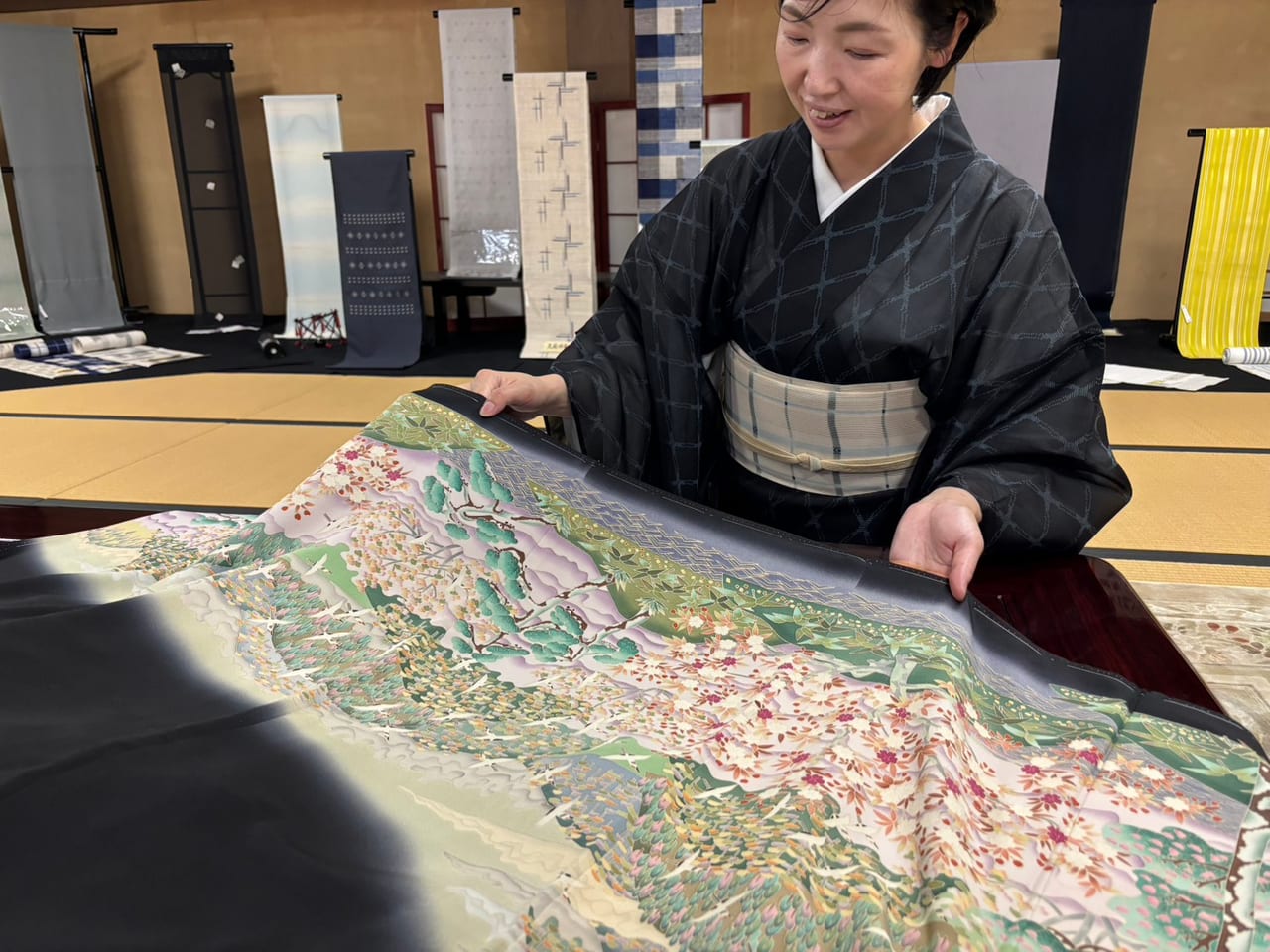 店内で着物を広げながら状態を確認する和服お手入れ処 絹友の相談風景