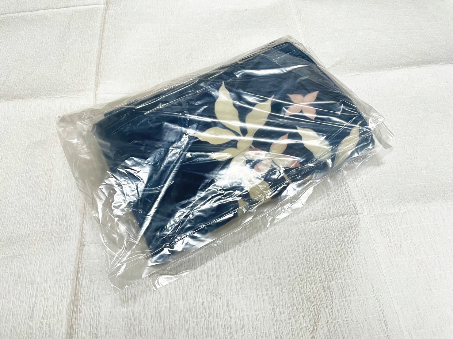 畳んだ着物をビニール袋に入れて水濡れを防ぐ様子